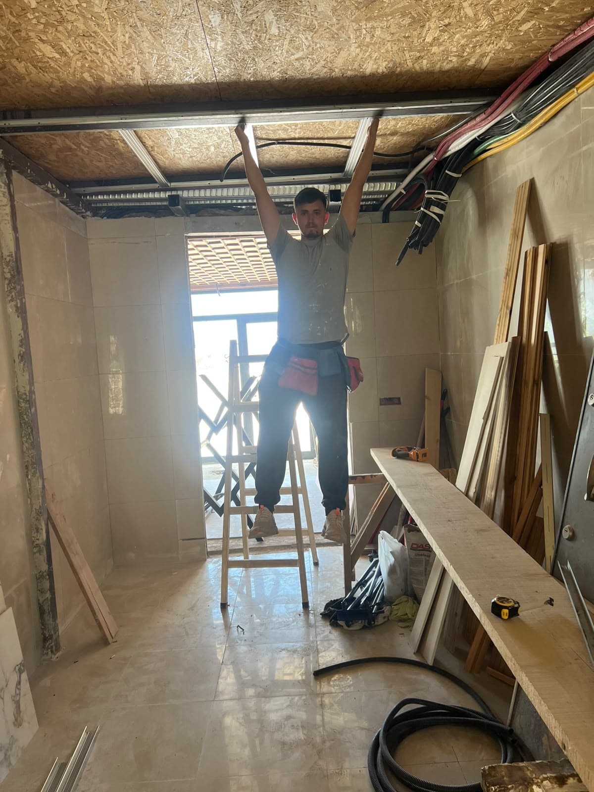 Punëtor gjatë montimit të skeletit metalik në tavan